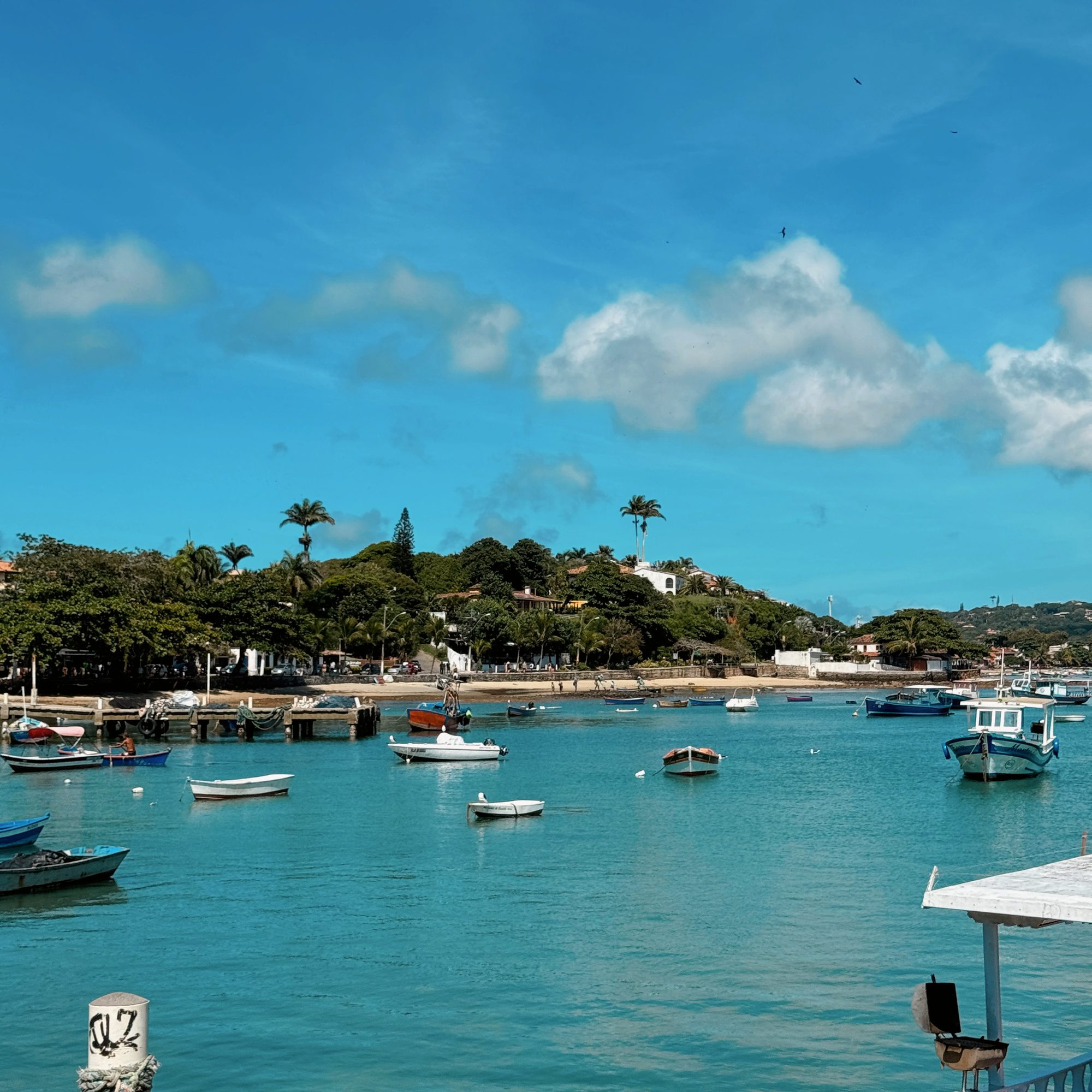 Porto de Búzios com barcos coloridos e Igreja de Sant’Anna ao fundo